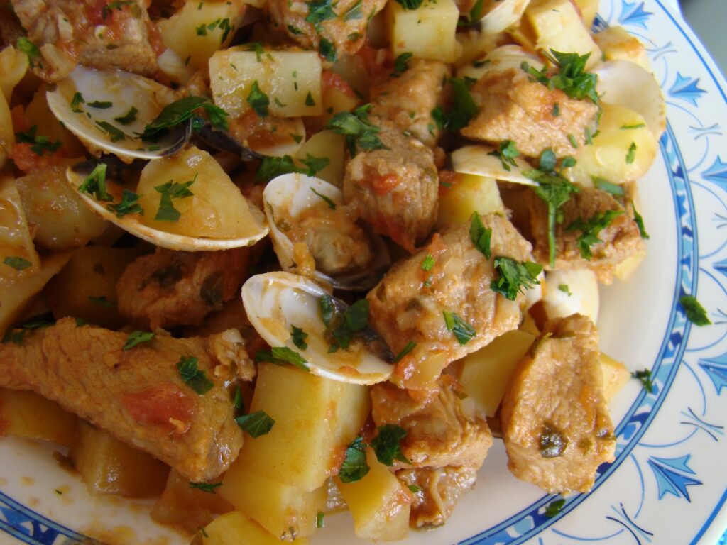 Carne de porco à alentejana caseira com ameijoas e batatas fritas, prato tradicional português cheio de sabor.