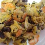 Ovos mexidos com camarão e cogumelos salteados, petisco português simples e saboroso.