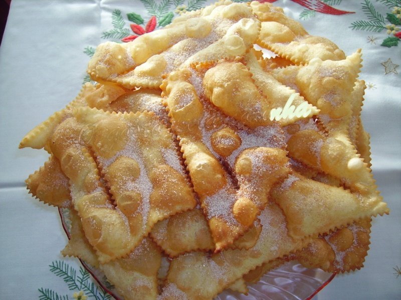 Filhoses tradicionais douradas, polvilhadas com açúcar e canela.